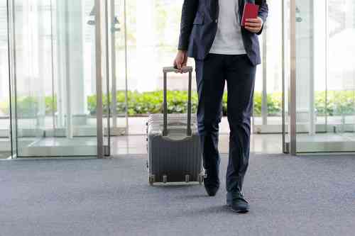 Mann mit Koffer am Flughafen